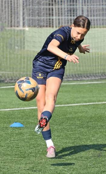 Jugadora controlando el balón en el aire durante el entrenamiento