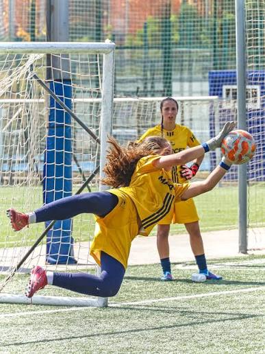 Portera del campus femenino deteniendo un balón en una parada espectacular